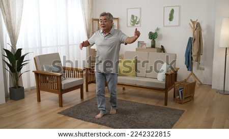 Smile senior romantic man dancing at home alone in cozy apartment. well-managed retired life concept. full length old grandpa standing on carpet step front and back practicing social dance indoors Royalty-Free Stock Photo #2242322815