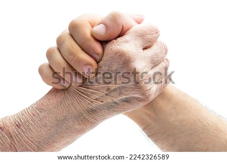 Arm wrestling  concept of old hand vs young isolated on white 
