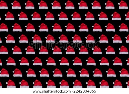 Repeating christmas pattern of santa claus hats on black background, festive pattern, new year concept. High quality photo