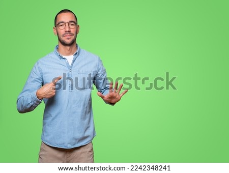 Friendly young man doing a gesture of keep calm