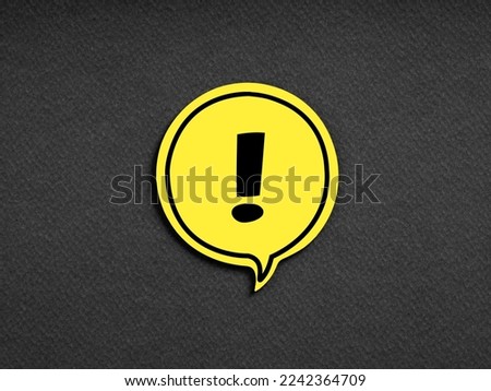 Exclamation mark on yellow speech bubble on black background. Attention, caution, warning, alert or danger concept.