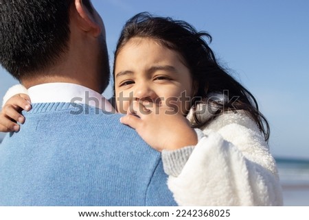 Cropped image of loving father and daughter on beach. Japanese family walking, hugging, dad carrying little girl. Leisure, family time, parenting concept