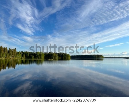 Forest trees silhouette reflection on the quiet lake surface, very peaceful, no people, lake reflection background
