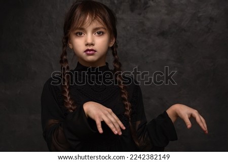A girl with braids in a gothic style on a dark background Royalty-Free Stock Photo #2242382149