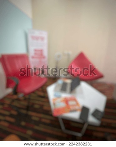 blurred background of an office room, there is a table and chairs. no people.