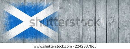 Flag of Scotland. Flag is painted on a gray wooden plank surface. Wooden background. Plywood surface. Copy space. Textured creative background