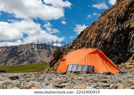 Outdoor travel solar panel charging. Camping equipment, alternative power source. Royalty-Free Stock Photo #2242400459