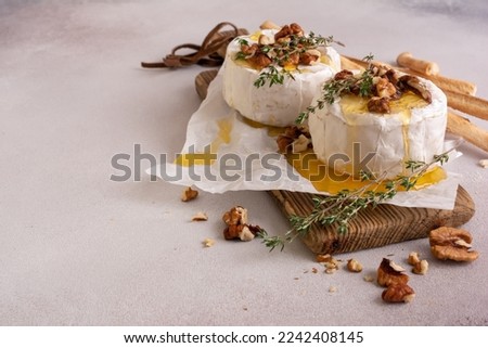 Gourmet meal of white brie cheese or camembert with thyme, walnut, honey and grissini bread stick for tasty dinner Royalty-Free Stock Photo #2242408145