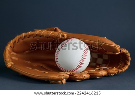 Catcher's mitt and baseball ball on dark background. Sports game