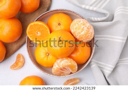 Fresh juicy tangerines on light grey table, flat lay Royalty-Free Stock Photo #2242423139