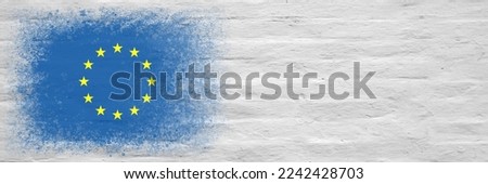 Flag of European Union. Flag painted on a white plastered brick wall. Brick background. Copy space. Textured creative background Royalty-Free Stock Photo #2242428703