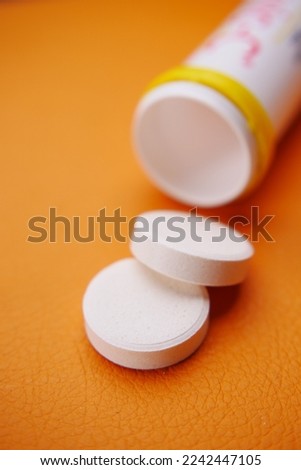 Effervescent soluble tablet pills on orange purple background 