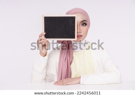 Asian hijab girl hold blank blackboard. Chalkboard for information. Advertisement promotion copy space.