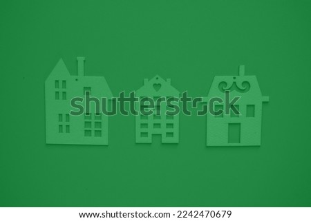 Flat wooden houses on a green background with a large view from above. The concept of buying your own home. Creative home ownership concept. Real estate related concept. Dream house offer concept.