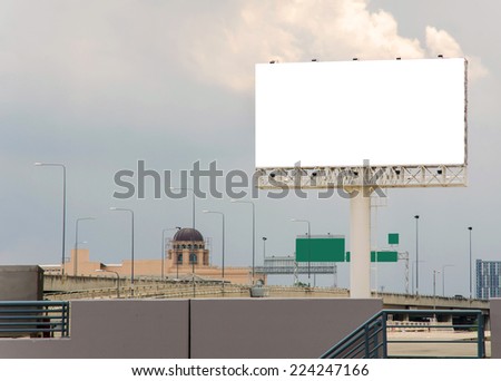 large blank billboard on road with city view background.