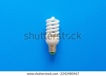 One light bulb on a blue paper background