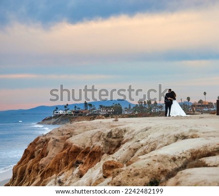View of a bride and groom ejoying the sunset at La Jolla Cove in southern California.