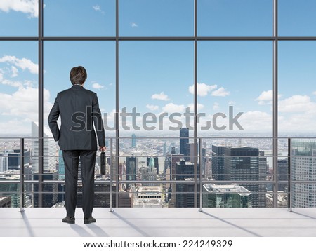Businessman looking out of office window. 