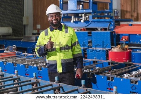 Portrait African American engineer with machine background at metal sheet factory