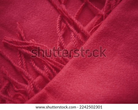Close up of red autumn and winter scarf made from polyester with fringe. High quality photo