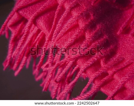 Close up of red autumn and winter scarf made from polyester with fringe. High quality photo