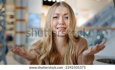 Puzzled Caucasian woman upset furious girl blonde lady indoor asks so what happened holding hands v looking dissatisfied at camera confused angry misunderstanding irritation reaction negative Royalty-Free Stock Photo #2242505371