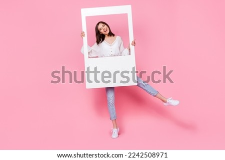 Full length photo of cheerful positive lady arm hold big white frame offer services photographer isolated on pink color background
