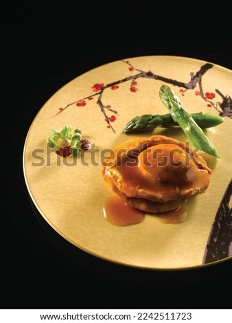 braised dried australian abalone in oyster sauce served in dish isolated on table top view of food Royalty-Free Stock Photo #2242511723