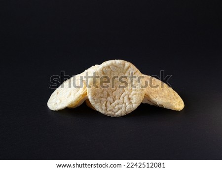 Puffed Potato Chips, Stacked on a plain black background with shadow, healthy potato snack.Puffed chis  Royalty-Free Stock Photo #2242512081