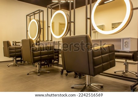 Premium coworking center for hair masters. Workplace of the hairdressers with illuminated mirrors and comfortable chairs. Concept of contemporary interior design for hairdresser. Beauty salon Royalty-Free Stock Photo #2242516569