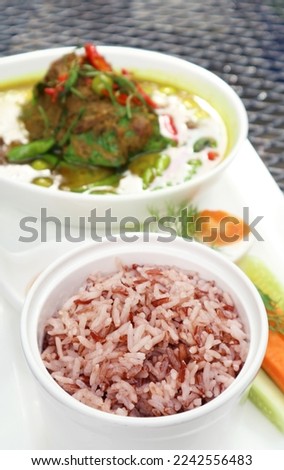 Closeup of Cooked Thai Red Cargo Rice Served with Thai Green Curry