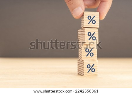 Interest rate, financial or mortgage rates concept. Hand picking a wooden block with percentage symbol icon. Copy space