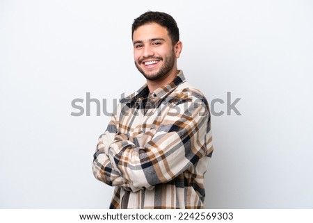 Young Brazilian man isolated on white background with arms crossed and looking forward Royalty-Free Stock Photo #2242569303