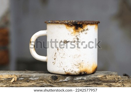 metal old dirty cup isolated. rusty iron cup, close-up. old tea utensils. a white mug stands on a wooden board. retro, vintage, Photo