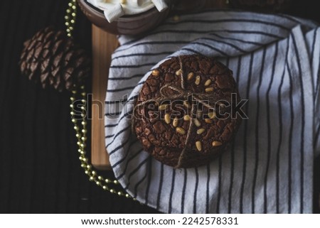 homemade brownie chocolate cookies with pine nuts on white towel and black desk on black background. Dark and moody stock food photography