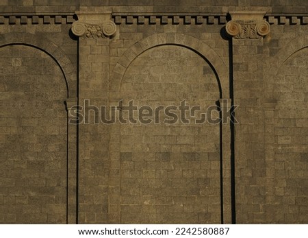 Ancient gothic stone wall with arches and columns. Weathered stone wall with columns