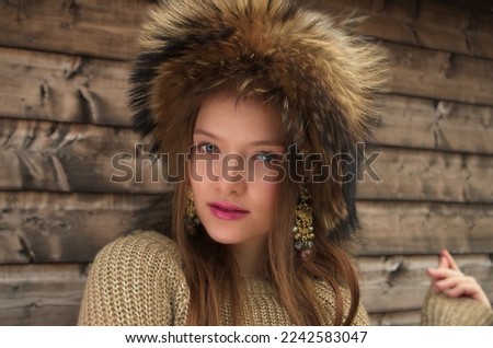 A portrait of beautiful young woman wearing a furry hat Royalty-Free Stock Photo #2242583047