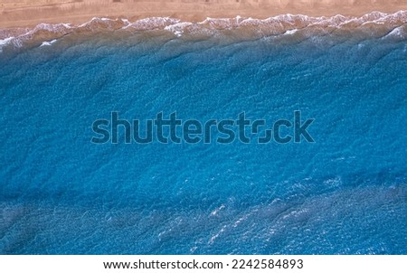 Concept summer sunny travel image. Turquoise water wave with sand beach background from aerial top view.