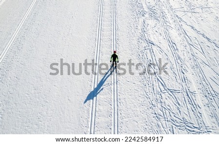 Aerial top view sportsman with cross country skiing sport background winter forest. Royalty-Free Stock Photo #2242584917