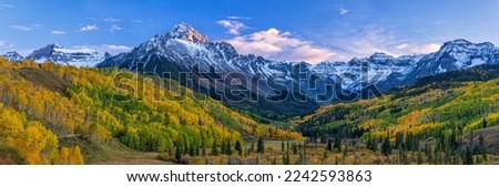 The last light of the setting sun hits the crags atop Mount Sneffels, with a mostly golden grove of quaking aspens below, in the San Juan Mountains near Ridgway, Colorado. Royalty-Free Stock Photo #2242593863