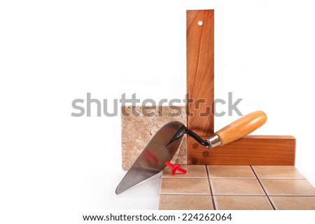 Trowel, wooden square and ceramic tiles on white background