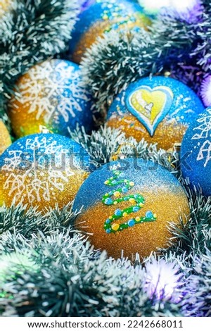 New Year's, Christmas card with decorative New Year's garland, lights and Christmas balls with patriotic Ukrainian drawings.