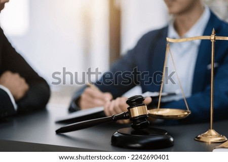 justice with scales and auction hammer, the team meeting at the law firm behind the concept of in office law.