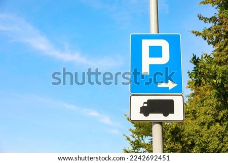 Post with different road signs Parking Right and Plate Indicating Trucks outdoors on sunny day. Space for text