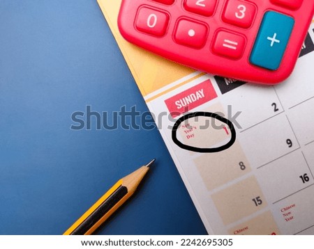 Top view pencil and calculator with a calendar marked with the new year date