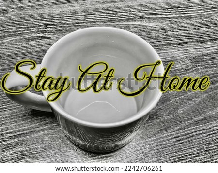 On the table show a mug with words stay at home