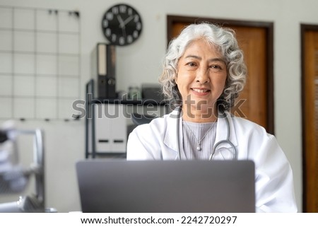Portrait of Asian doctor working at her table in clinic

