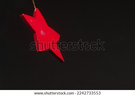 Red glitter star shaped christmas decoration isolated on black background