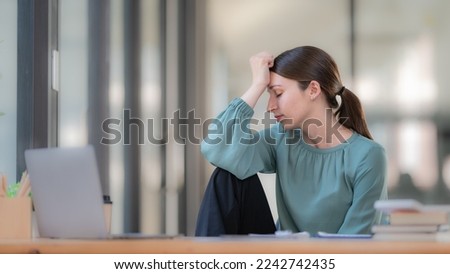 Portrait of a female office worker feeling stressed while working in the office room.