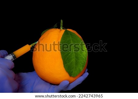 Orange with inserted syringe . Grapefruit symbolizes the fear of injections. Fruit contamination with chemicals. Genetic modification of food Royalty-Free Stock Photo #2242743965